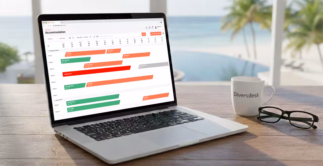 A resort manager overlooking a beautiful dive resort while using the Diversdesk dashboard on a laptop.